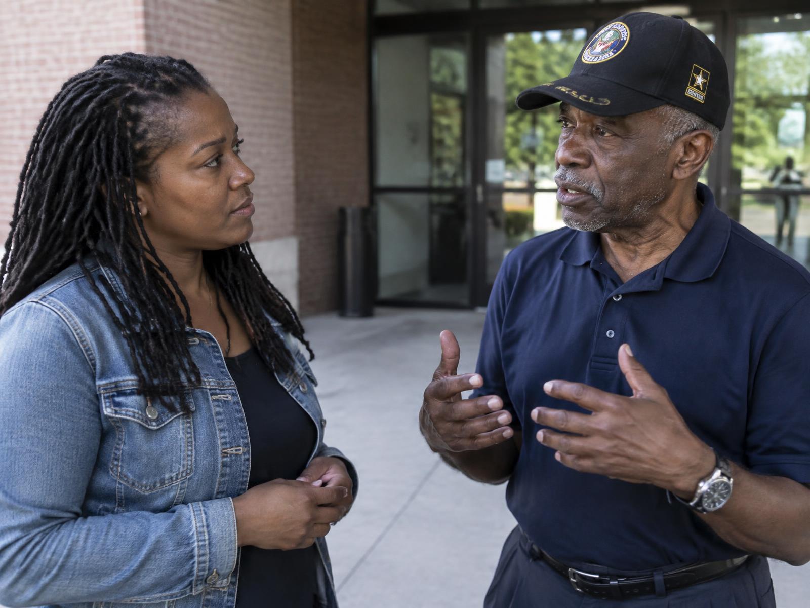 Two veterans, a woman and an older man, talking together outside a community center